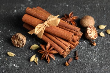 Different aromatic spices on grey textured table, closeup
