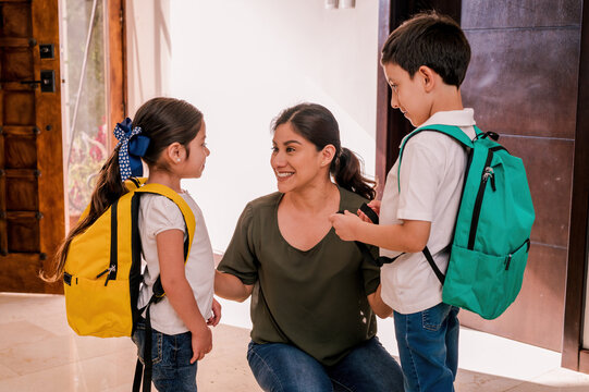 The mother talks with her children before they leave for school.