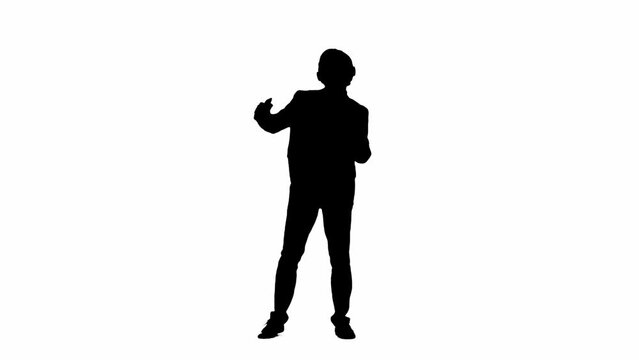Modern businessman advertising concept. Man in studio isolated on white background with alpha channel. A black silhouette of a businessman in a suit listens to music on headphones and dances.