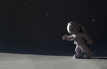 Little toy astronaut on black background. International human space flight day banner. Selective focus, copy space - obrazy, fototapety, plakaty