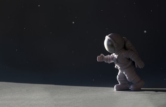 Little toy astronaut on black background. International human space flight day banner. Selective focus, copy space