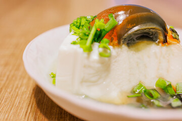 a plate of exquisite century egg tofu, sprinkled with fresh green onions