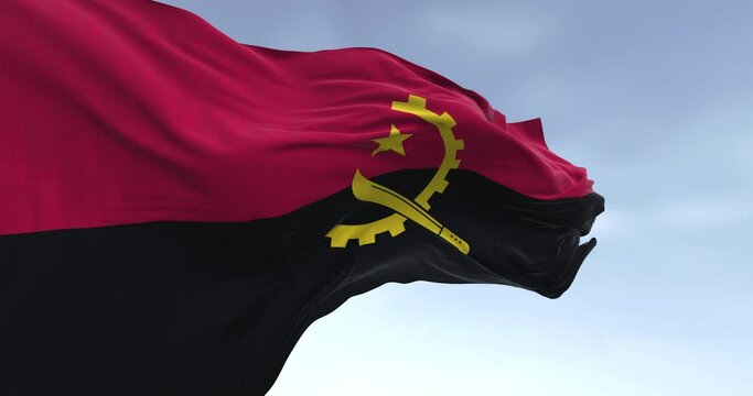 Close-up of Angola national flag waving in the wind on a clear day