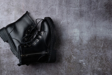 Stylish black boots on a gray background