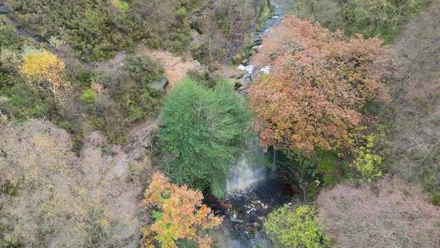 Aerial drone footage of  a river winging through a moorland scene. Woodlands, waterfalls and countryside vistas. UK