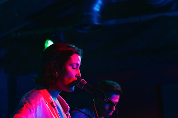 Musicians In Stage With Colorful Lights Performing In A Live Concert