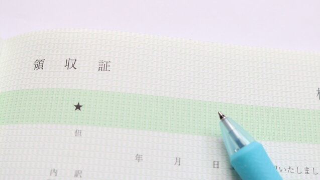 手書きの領収書とペン現金で集金