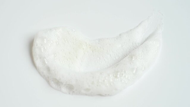 Smear of facial cleansing foam on white background close-up.
