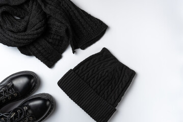 Winter total black accessories on white background. Flat lay, top view.