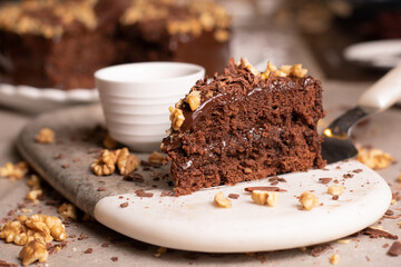 Pedazo de torta de chocolate con taza blanca