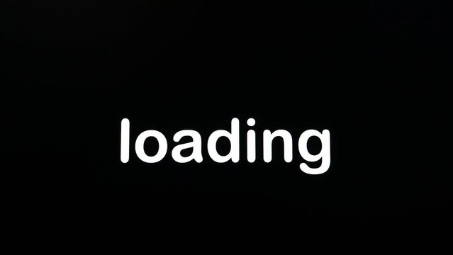 Writing on the screen with a flashing paragraph forming the word loading in white on a black background