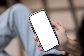 Close-up image of a man using his smartphone while sitting outdoors. People and technology concepts