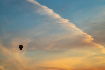 Hot air balloon silhouette in the evening sky. Composition of nature and blue sky background