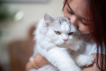 Portrait of a young woman hugging a cute cat