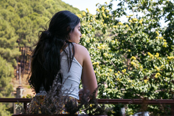 Woman watching forest views from the balcony of a house