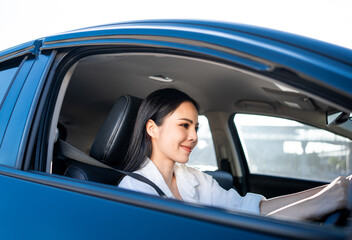 Fototapeta na wymiar Young beautiful asian business women getting new car. She very happy and excited. Smiling female driving vehicle on the road on a bright day with sun light. Business woman buying driving new car