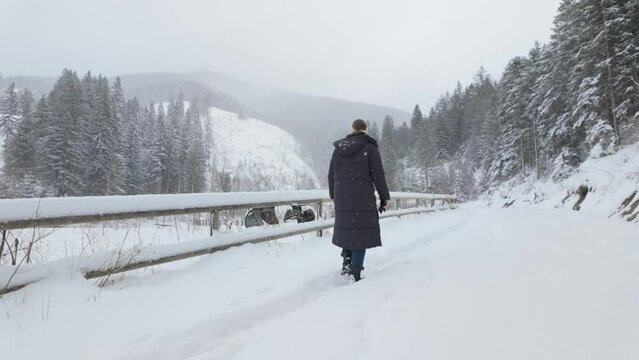 Person Walking To Snowy Path Along The Wooden Fence In Winter. - slow motion shot