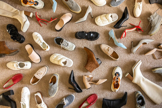 Different female shoes abstract arrangement on beige carpet flooring fashion shopping background