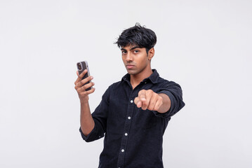 Young man pointing while taking a selfie with smartphone
