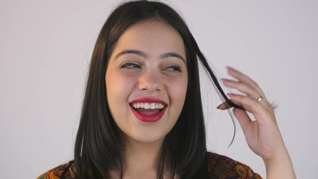 Funny Indian young woman playing with her hair - facial expressions  pout  smile  brown skin. A pretty girl making moustache with her hair - gesture  mimicking a boy  acting  cheerful  happy  joyfu...