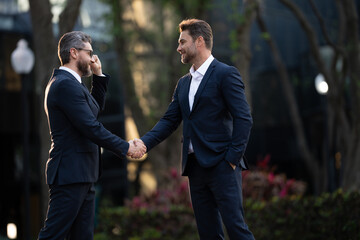 Businessman handshake for teamwork ,successful. Business network concept. Management strategy. Human resources. businessman greeting and making handshake with a businessman outdoors in city walkway.