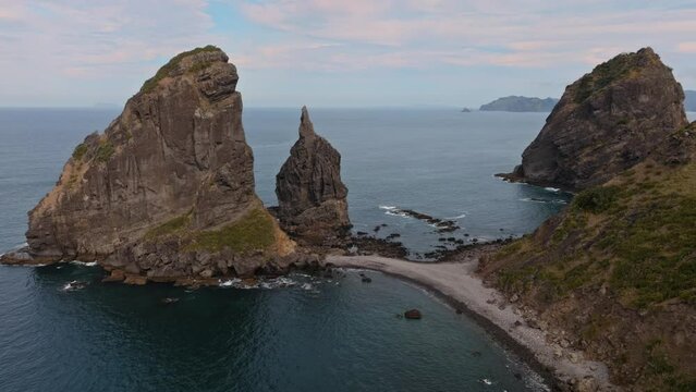 Aerial: Rocky headland and ocean in Fletcher Bay, Coromandel Peninsula, New Zealand.