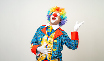 Laughing Mr Clown. Portrait of Funny happy face comedian Clown man in colorful costume wearing wig listen music. Happy expression amazed bozo dancing with music in various pose on white background.