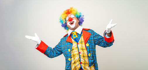 Laughing Mr Clown. Portrait of Funny happy face comedian Clown man in colorful costume wearing wig...