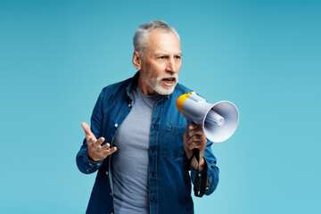 Serious, 60 years old senior man wearing stylish casual clothes holding loudspeaker looking away