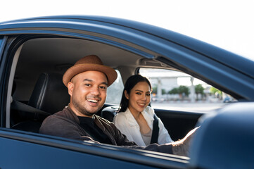 Young asian couple man and woman travel by car on a bright day beautiful blue sky sunlight. They was happy along the way trip. safety driving car vacation. Travel tourism vehicle.