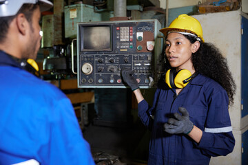 worker or engineer training and teaching how to use machine control with coworker in factory
