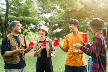 Cheers! Group of asian people friend party camping in nature making toasting with soft drink and...