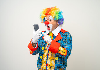 Mr Clown. Portrait of Funny face Clown man in colorful uniform standing holding smartphone. Happy...