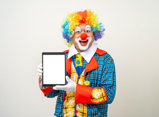 Mr Clown. Portrait of Funny face Clown man in colorful uniform standing holding tablet. Happy...