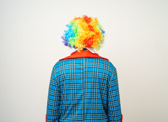 Rear view Mr Clown. Back behind Portrait of Funny comedian face Clown man in colorful uniform wearing wig standing. Happy expression male bozo in various pose on isolated background.