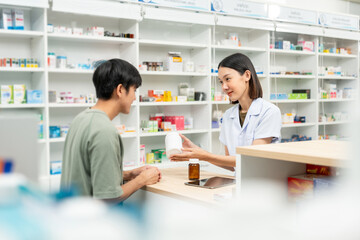 Pharmacist recommends medicines to customers.Taking the questions of medication. Asian female pharmacist giving prescription medications to customers at drugstore shelves.