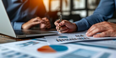 Business professionals analyzing financial data with charts and laptop.
