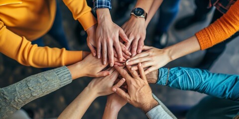 Overhead view of a team hands together in unity. - obrazy, fototapety, plakaty