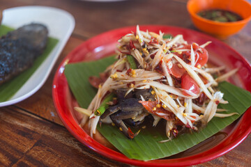 Papaya salad with salted crab and fermented fiish, Famous Northeastern food in Thailand. The famous local Thai street food with hot and spicy