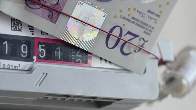 rotating numbers in a gas meter with a 20 pounds note on top, concept of expensive gas