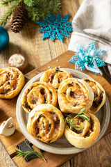 Obraz na płótnie Canvas Pizza rolls puff pastry stuffed with prosciutto bacon, mushrooms and cheese on the Christmas table, italian appetizers.