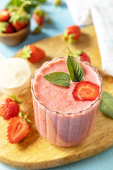 Fresh milk, strawberry drinks on wooden board on a stone background, protein shake with fresh berries.
