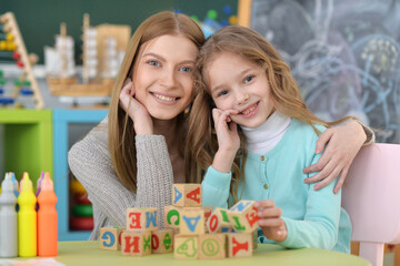 Portrait of little girl and her mother playing