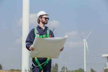 man engineer worker wearing safety uniform holding and reading blueprint working about renewable...