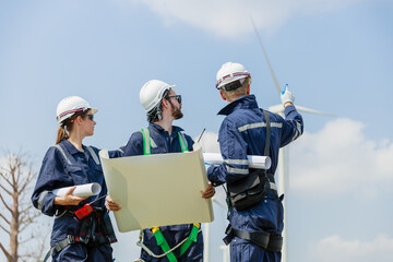 Team engineer wind turbine worker safety uniform holding blueprint survey discuss operational...