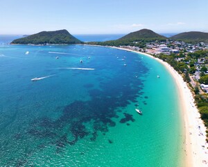 Shoal Bay in NSW's Port Stephens on a summer's day, showcasing crystal clear water with boat trails