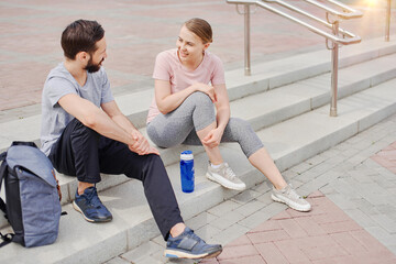 Couple sportsmen chatting outdoor, preparing for training