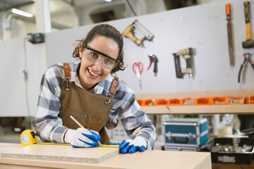 happy women enjoy working designer in wood workshop. Joiner wood apron worker furniture hand...