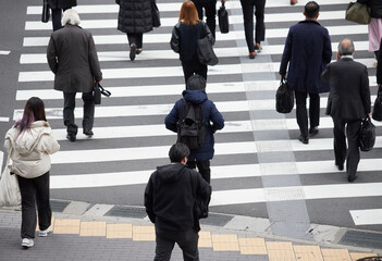 冬の都市の交差点の横断歩道を渡る人々の姿