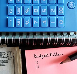 Money calculator with note written BUDGET KILLERS - to identify small expenses sneaky,...